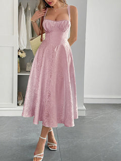 Woman wearing a pink lace-up sleeveless midi dress with ruched bodice and flared skirt