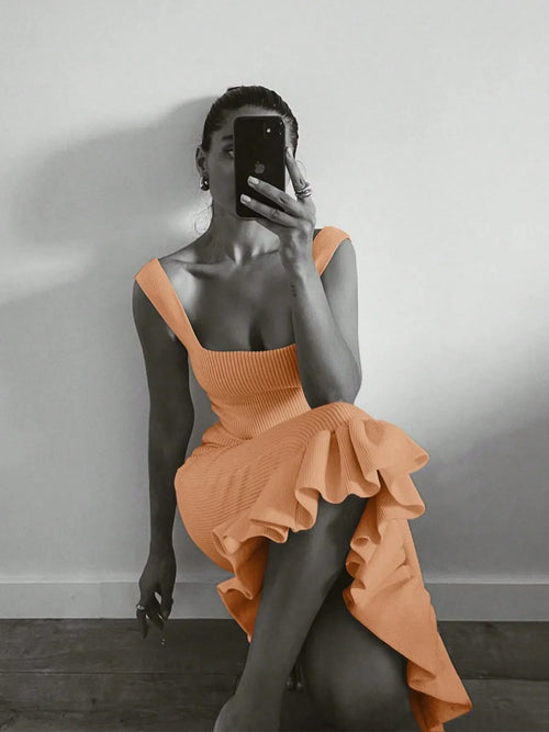 Woman wearing ribbed knit bodycon dress with ruffle hem taking a mirror selfie