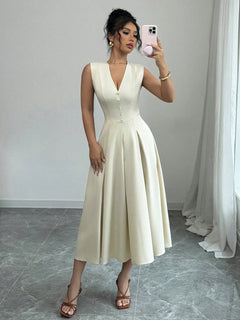 Woman wearing a buttoned V-neck sleeveless midi dress in cream color taking a mirror selfie